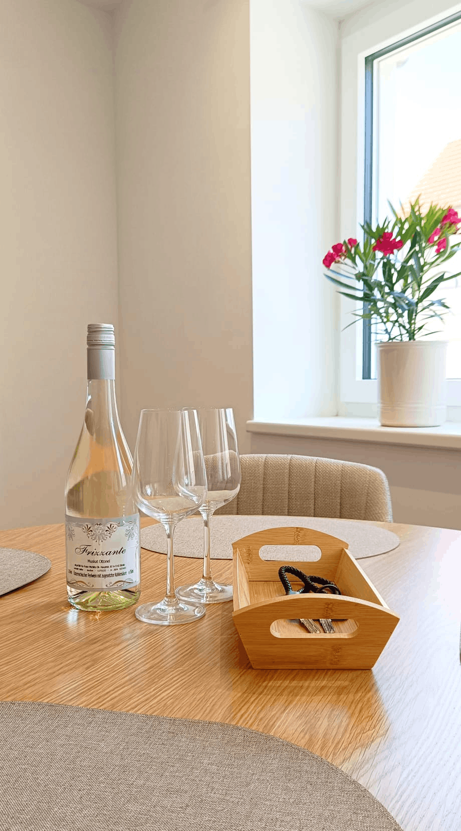 Wohnzimmer Tisch auf dem eine Flasche Wain und zwei Weinglässer stehen