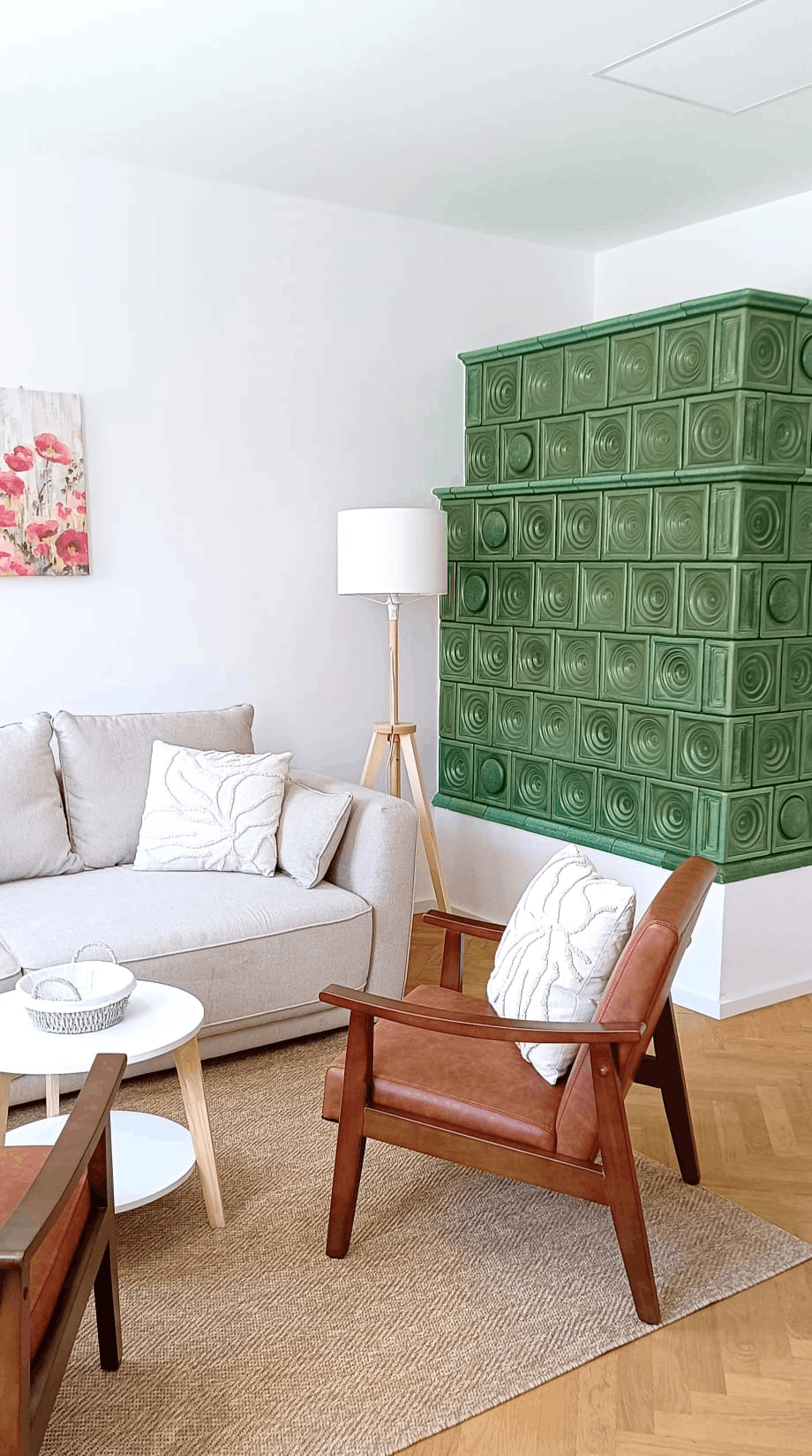 Wohnzimmer mit Couch und Sesseln und einen Kamin mit grünnen Fliesen